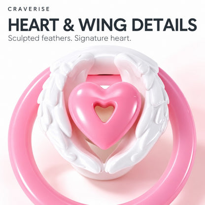 Close-up of sculpted white feathered wings and the pink heart-shaped centerpiece of an inverted chastity cage.